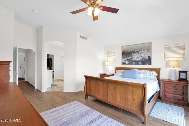 4611 E Night Glow Dr, Cave Creek, AZ 85331 - bedroom with vaulted ceiling, wood finished floors, arched walkways, a ceiling fan, and baseboards