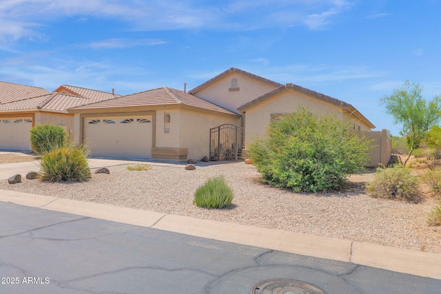 4611 E Night Glow Dr, Cave Creek, AZ 85331 - view of front of home with a garage, stucco siding, a gate, concrete driveway, and a tile roof
