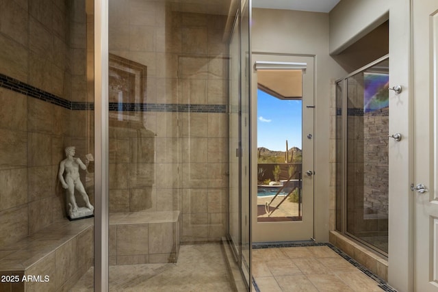 bathroom with a shower with shower door and tile patterned flooring