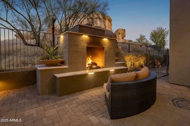 patio terrace at dusk with an outdoor fireplace