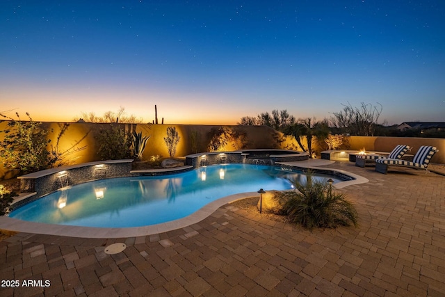 pool at dusk with an in ground hot tub, pool water feature, a patio area, and a fire pit