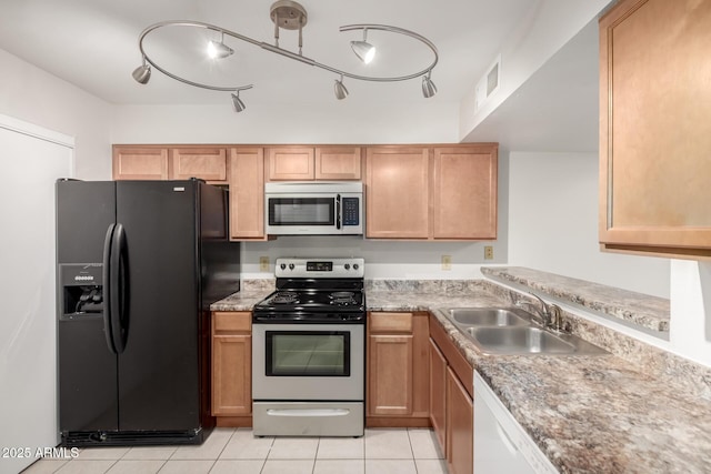 kitchen with light tile patterned floors, stainless steel appliances, a sink, and visible vents