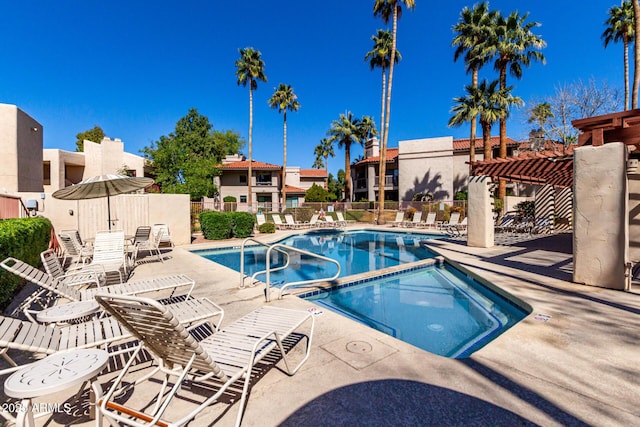 pool with a community hot tub, a patio area, and fence