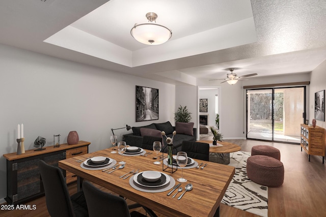 dining space with a ceiling fan and wood finished floors