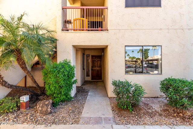 doorway to property featuring a balcony and stucco siding