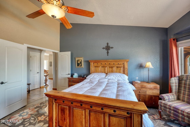 bedroom featuring arched walkways, ceiling fan, a textured ceiling, and lofted ceiling