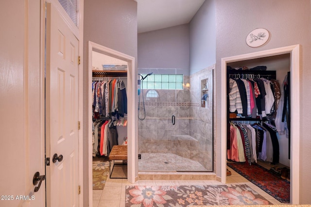 full bathroom featuring a stall shower, tile patterned flooring, and a spacious closet