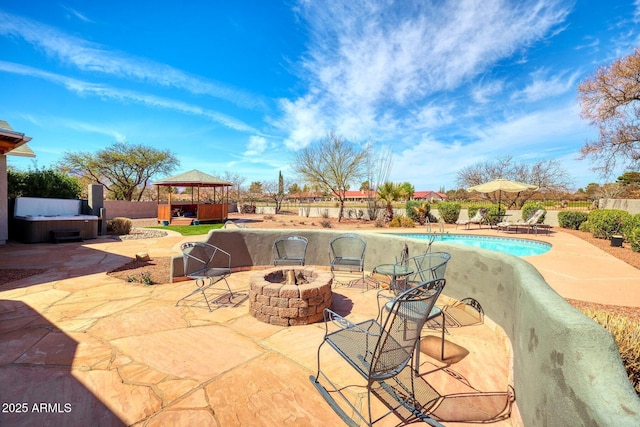 view of pool with a fenced in pool, a hot tub, a gazebo, an outdoor fire pit, and a patio area