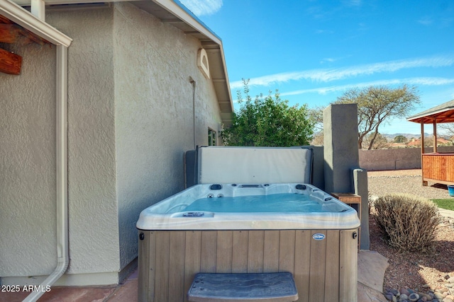 exterior space with a hot tub and fence