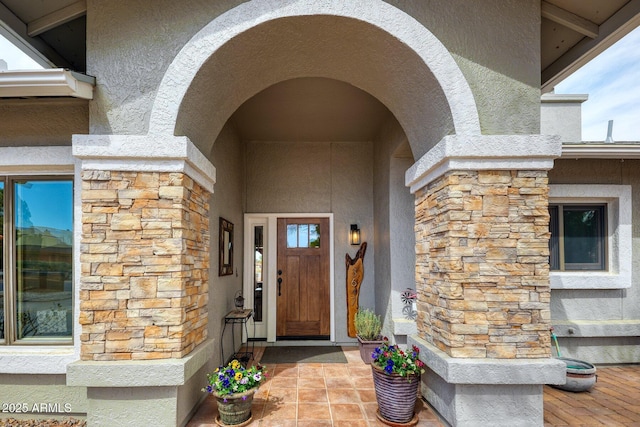 entrance to property with stone siding and stucco siding