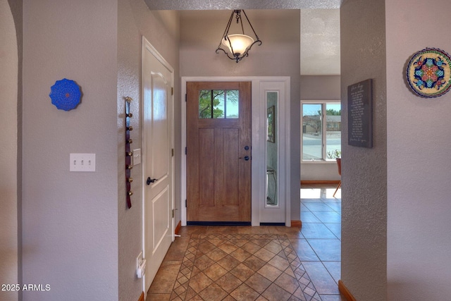 tiled foyer entrance with a textured wall