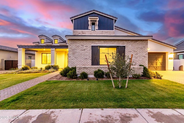 view of front of property featuring a garage and a lawn