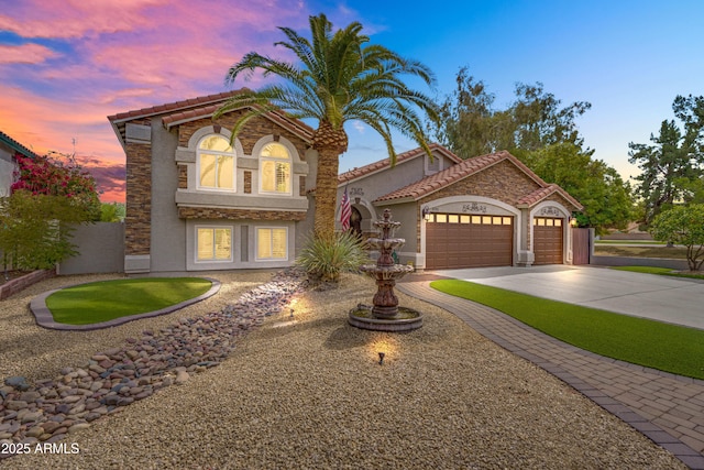 8781 S Mill Ave, Tempe, AZ 85284 - mediterranean / spanish-style house with a tiled roof, stucco siding, driveway, stone siding, and an attached garage