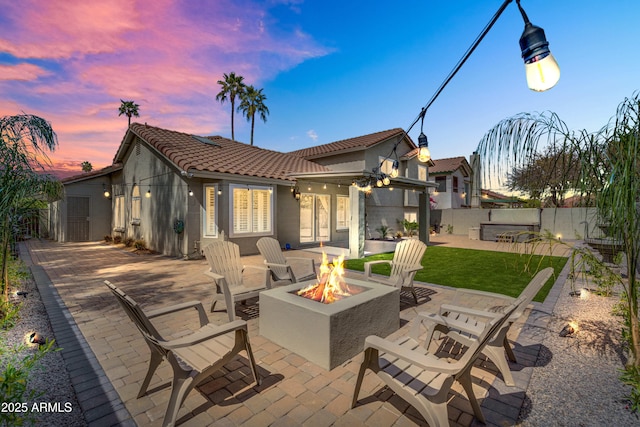 8781 S Mill Ave, Tempe, AZ 85284 - back of house at dusk with a patio, fence, stucco siding, a fire pit, and a tiled roof