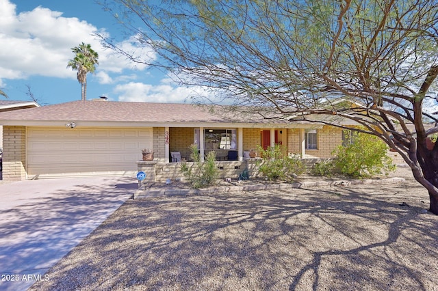 ranch-style home with covered porch, concrete driveway, brick siding, and an attached garage