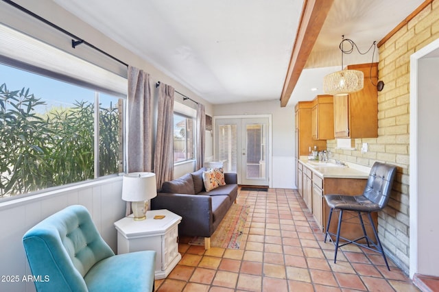 living room featuring french doors, beamed ceiling, plenty of natural light, and light tile patterned flooring