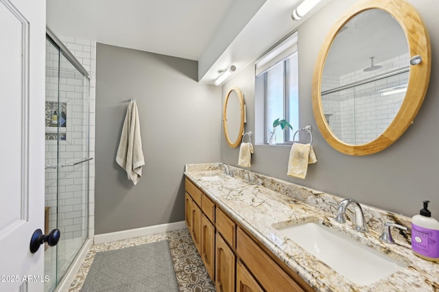 bathroom featuring a sink, a shower stall, and baseboards