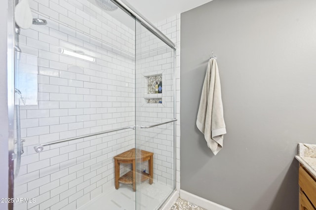 bathroom featuring a stall shower, vanity, and baseboards