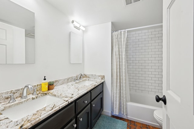 full bathroom with toilet, double vanity, a sink, and visible vents