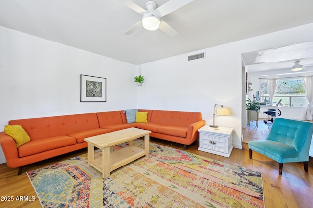 living room featuring ceiling fan, wood finished floors, and visible vents