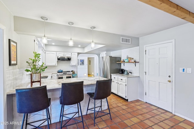 kitchen with stainless steel appliances, tasteful backsplash, visible vents, white cabinets, and a peninsula