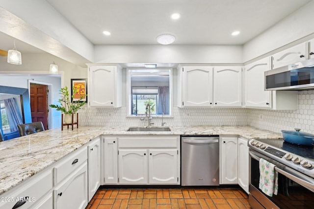 kitchen with recessed lighting, a sink, white cabinetry, appliances with stainless steel finishes, and backsplash