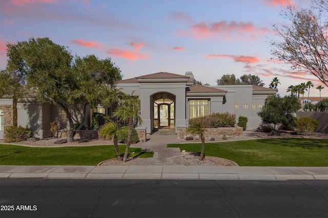 mediterranean / spanish house featuring a lawn