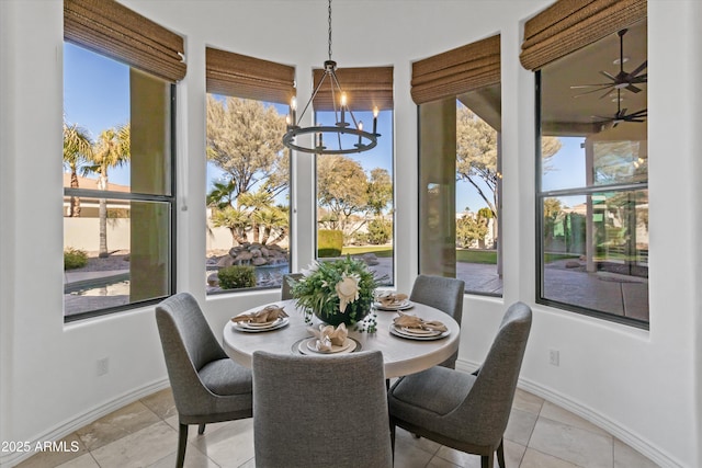 dining area featuring light tile patterned flooring and ceiling fan with notable chandelier