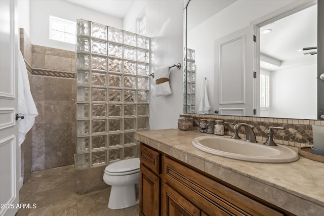 bathroom featuring vanity, toilet, and a shower