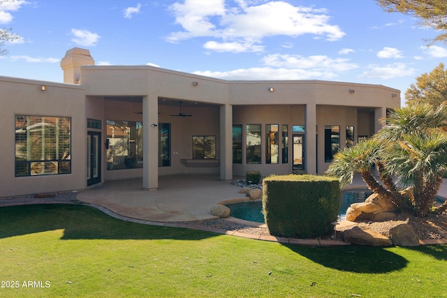 back of house featuring a patio, ceiling fan, and a lawn