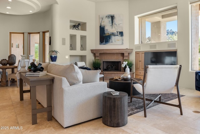 living area with a fireplace and a towering ceiling