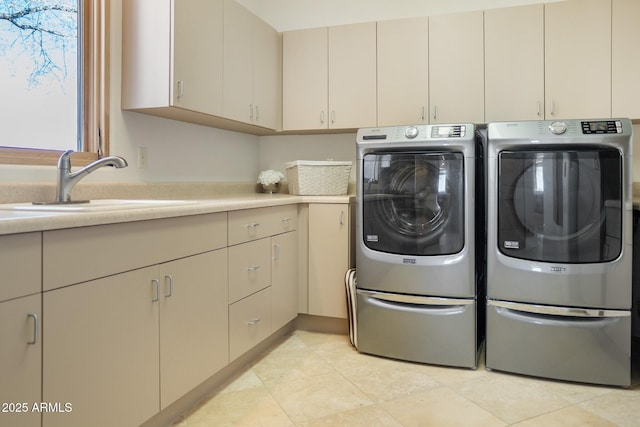 clothes washing area featuring cabinet space, washing machine and dryer, a sink, and light tile patterned flooring