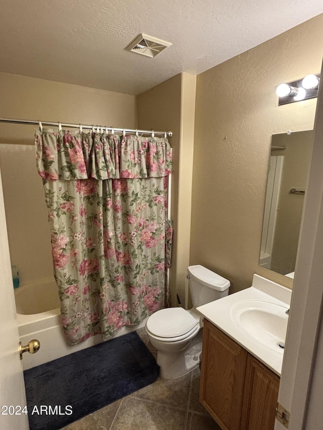 full bathroom with shower / tub combo with curtain, vanity, toilet, tile patterned floors, and a textured ceiling