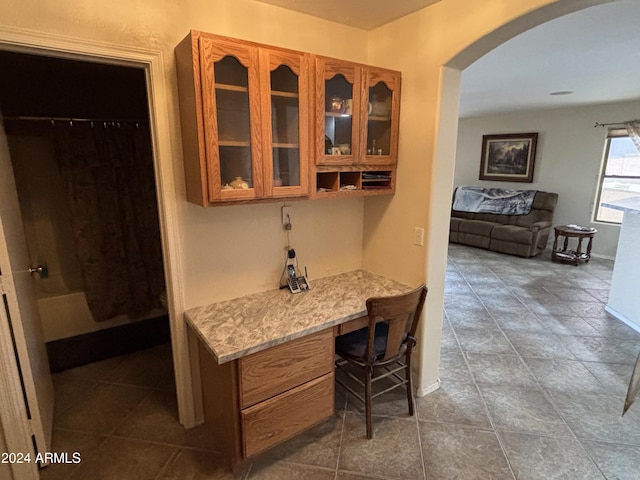 bar with light stone counters and built in desk