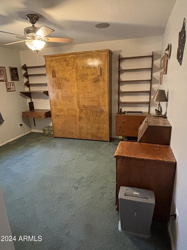 interior space featuring ceiling fan and dark carpet