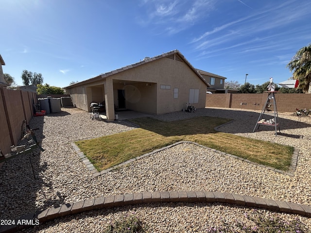 rear view of property featuring a patio and a lawn