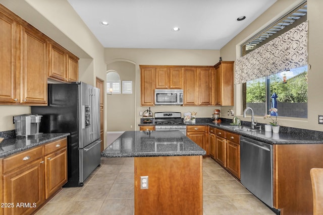 3859 N El Sereno St, Mesa, AZ 85207 - kitchen featuring stainless steel appliances, a sink, a kitchen island, dark stone counters, and brown cabinetry