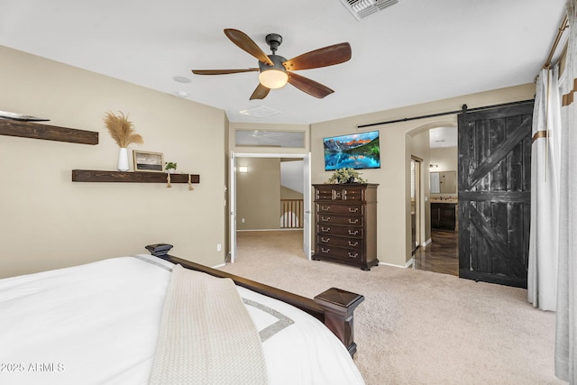 3859 N El Sereno St, Mesa, AZ 85207 - carpeted bedroom featuring arched walkways, baseboards, a barn door, ceiling fan, and connected bathroom