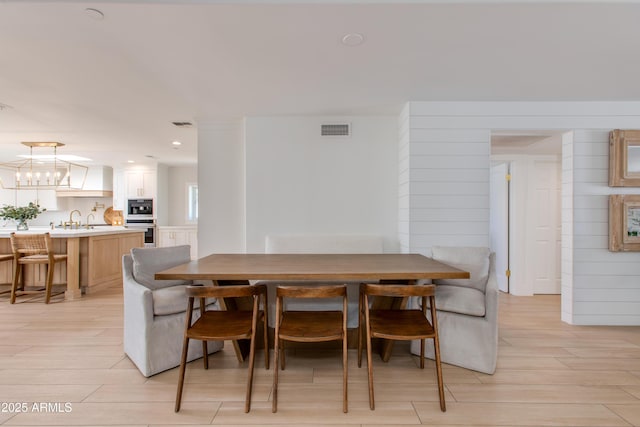 dining space featuring an inviting chandelier, recessed lighting, light wood-style flooring, and visible vents