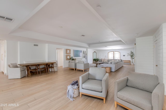 living area with light wood-style floors and visible vents