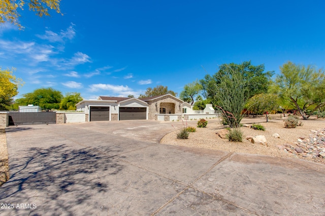 view of front of house with a garage, a gate, a fenced front yard, and concrete driveway