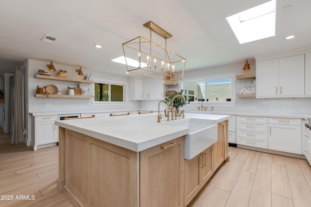 kitchen featuring open shelves, a sink, decorative backsplash, and light countertops