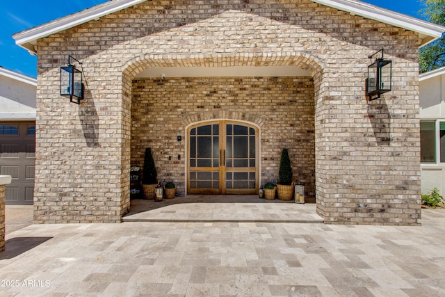 entrance to property featuring brick siding and french doors