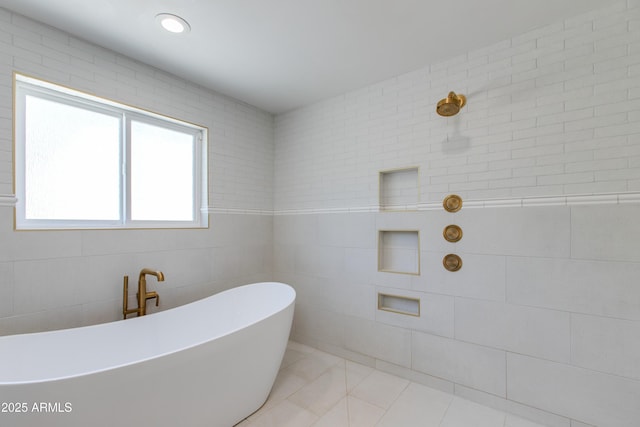 bathroom with a freestanding tub, tile walls, a tile shower, and tile patterned floors