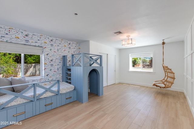 unfurnished living room with light wood-style floors, baseboards, a notable chandelier, and visible vents