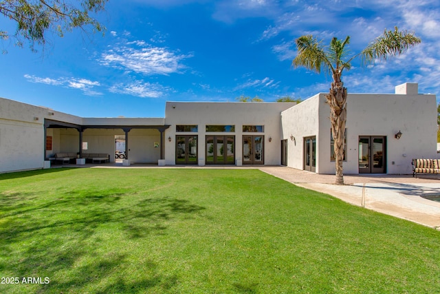 back of house featuring an outdoor living space, a yard, and french doors