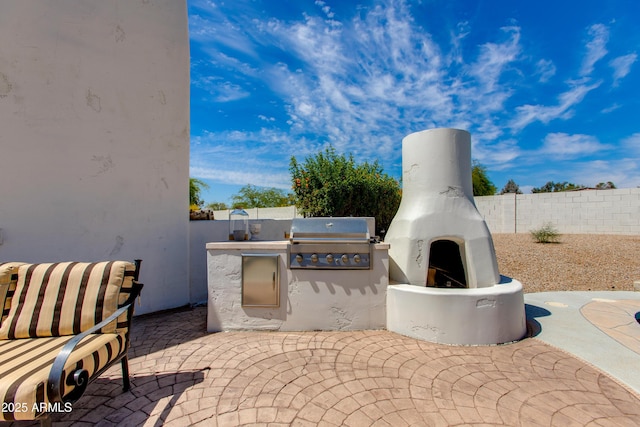 view of patio with grilling area, exterior kitchen, and a fenced backyard