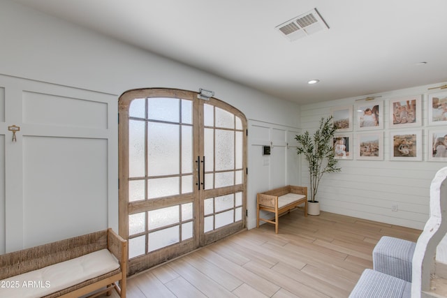 sitting room with visible vents, recessed lighting, light wood-style floors, and french doors