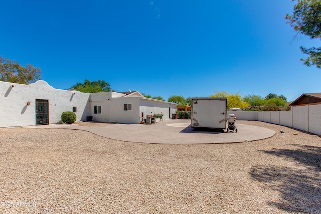 rear view of property featuring fence, a patio, and stucco siding