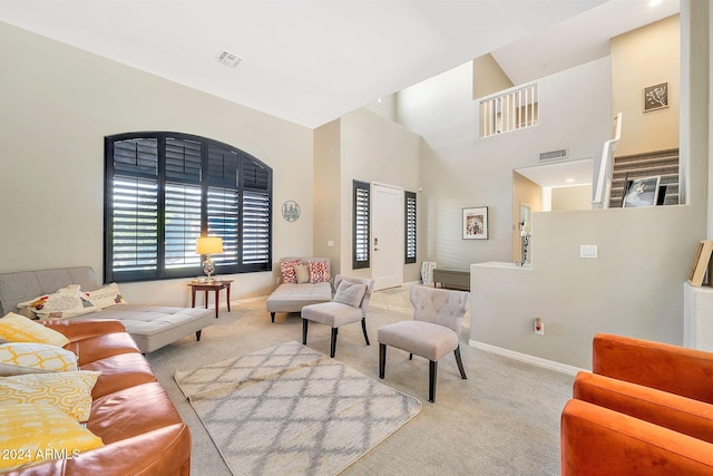 carpeted living room featuring a towering ceiling